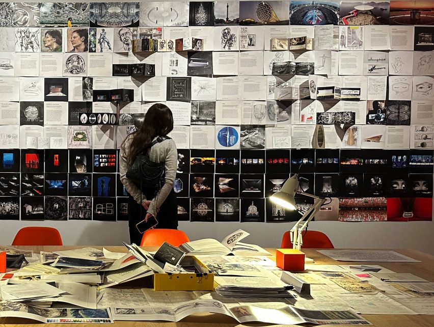 a person looking at a wall of sketches and drawings