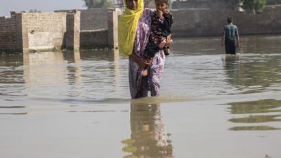 A woman holding her child during floods in Pakistan in 2022
