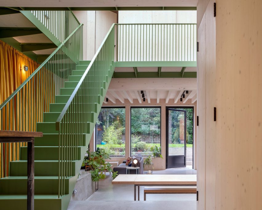 Green-painted stairs in an open-plan living area