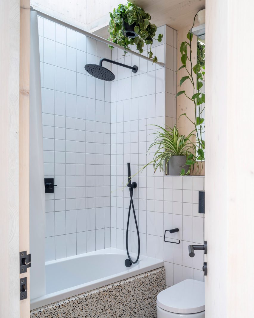 Bathroom with a white bathtub and white wall tiles