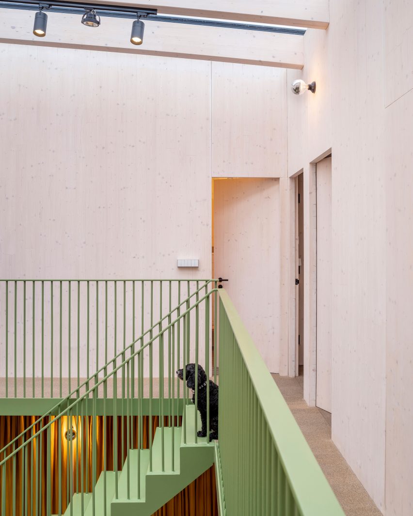 Top of a green-painted metal staircase in an atrium