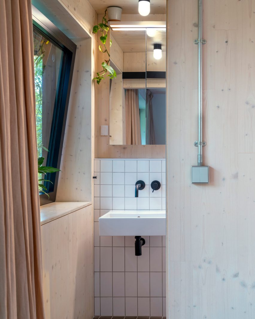Bathroom with plywood walls and white tiled splash backs