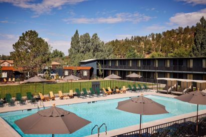 Motel rooms surrounding a central lawn and swimming pool