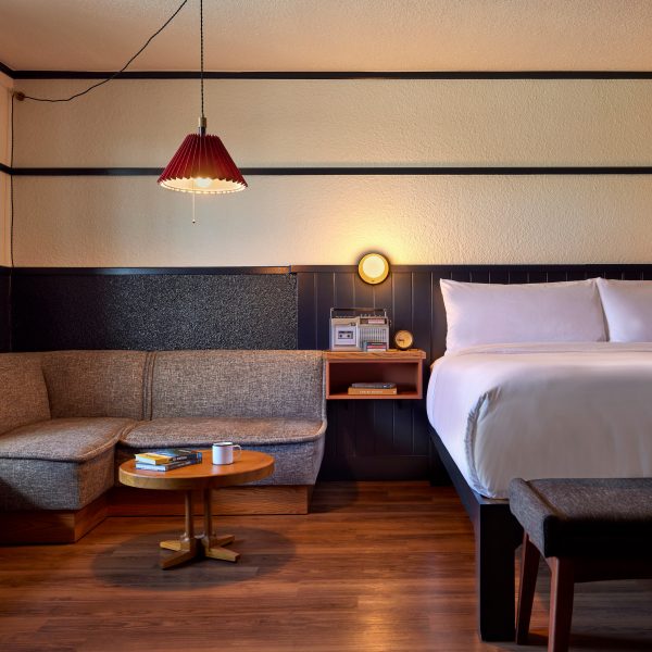 Guest room with low cushioned seating beside a double bed