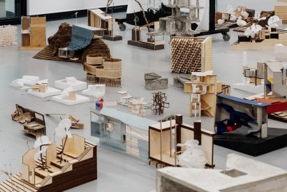 A studio space with models on floor and drawings on walls