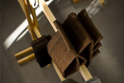 3D printed clay structure on wooden post