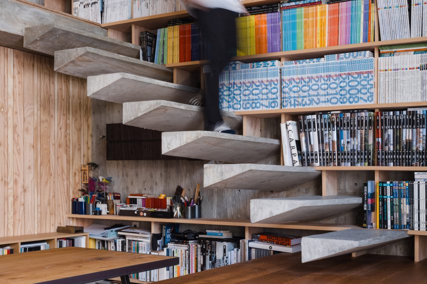 Floating concrete stairs on a bookshelf wall