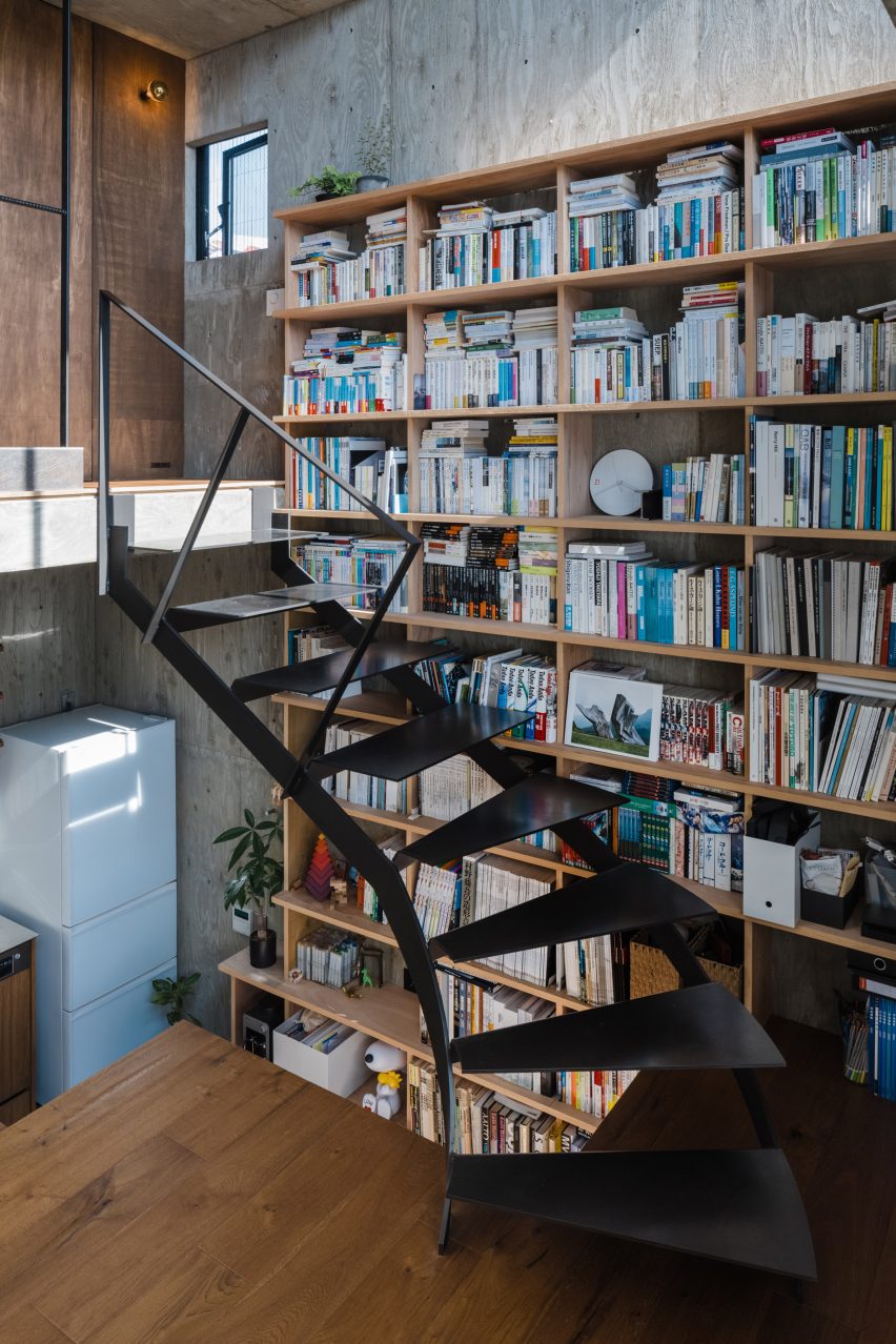 Black metal staircase next to bookshelves