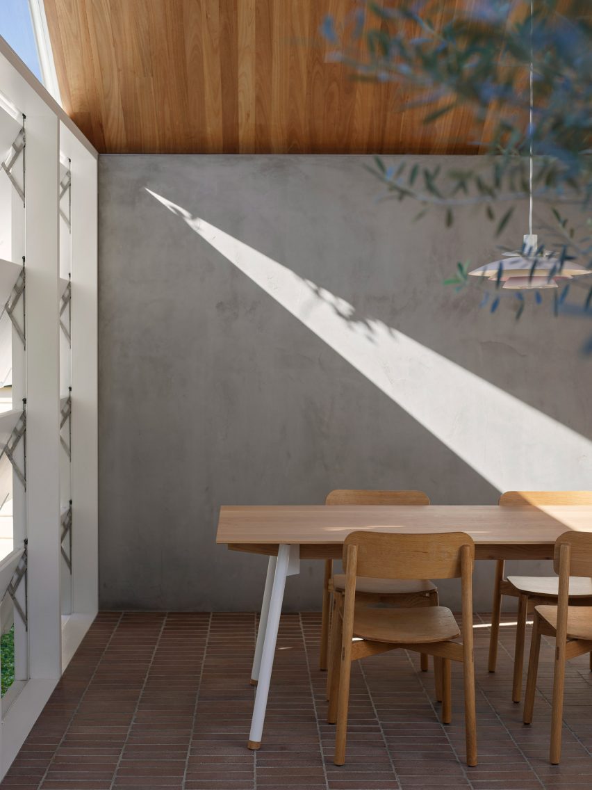 Dining room with a concrete wall and brick flooring
