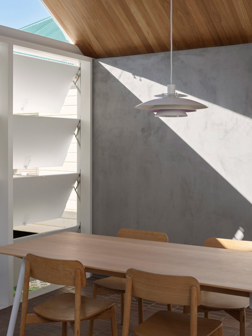 Dining room with concrete walls and a timber table