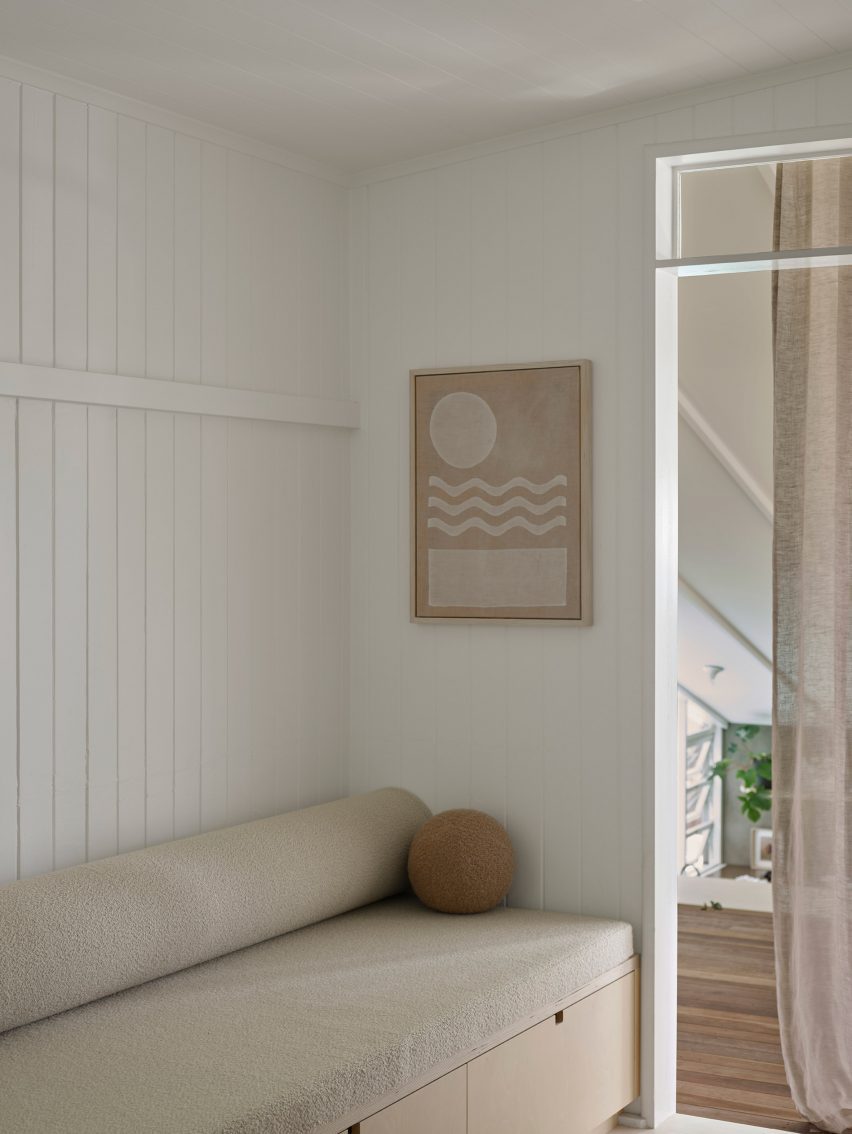 Living room with white timber board walls and built-in sofa
