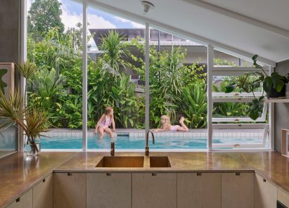 Kitchen overlooking an outdoor home swimming pool