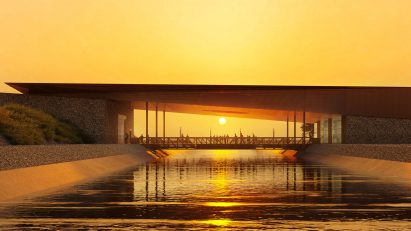 Long building over canal with sun in the background