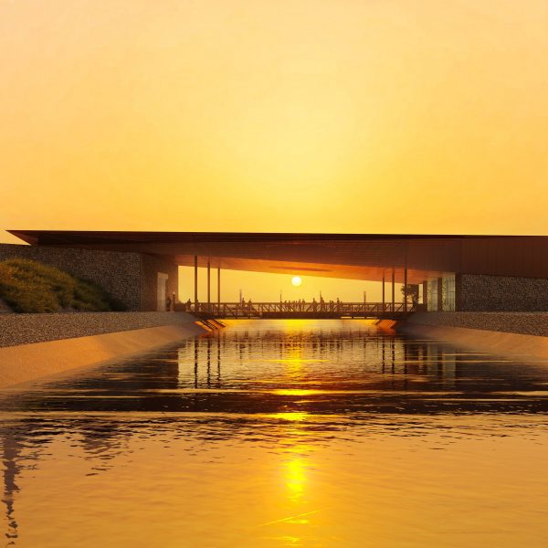 Long building over canal with sun in the background