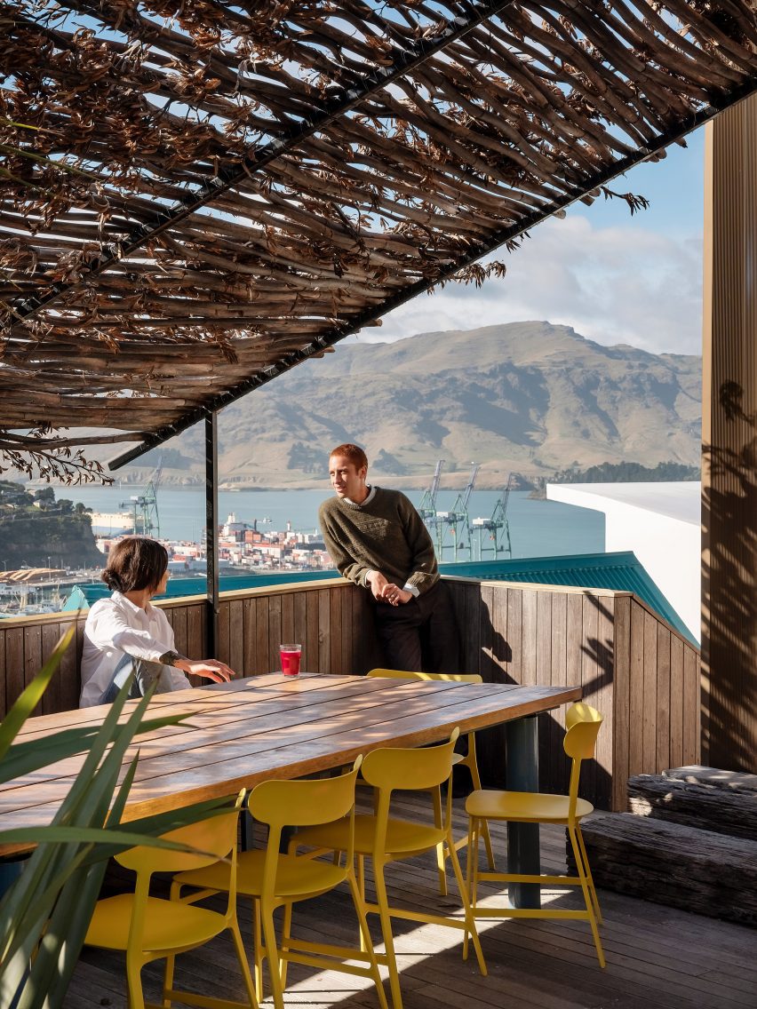 Yellow chairs by Noho arranged around wooden dining table