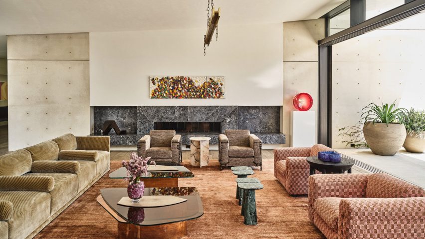 Sofas and chairs in sitting room with concrete walls