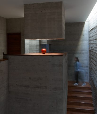 Staircase below white plaster ceilings in house designed by Lucio Muniain