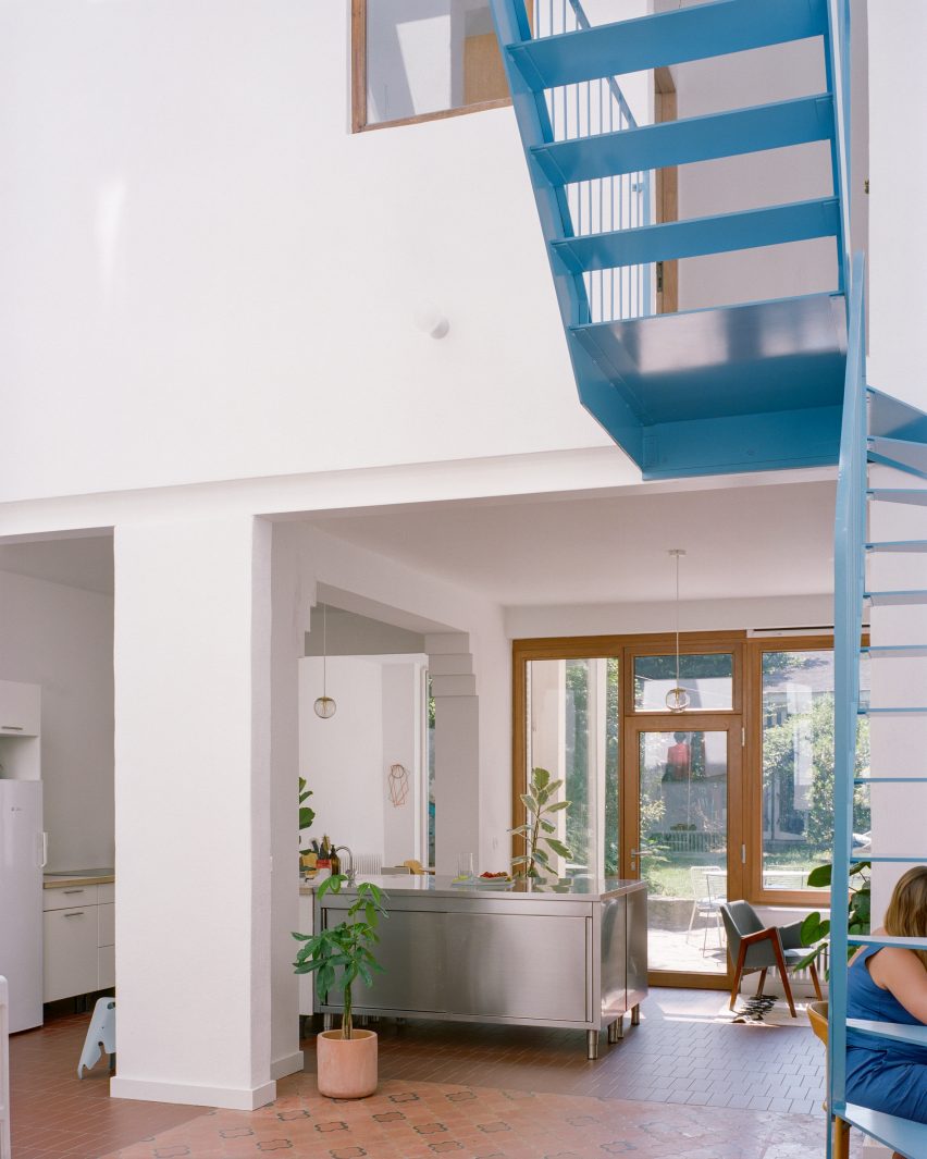 Blue metal staircase in a double-height atrium