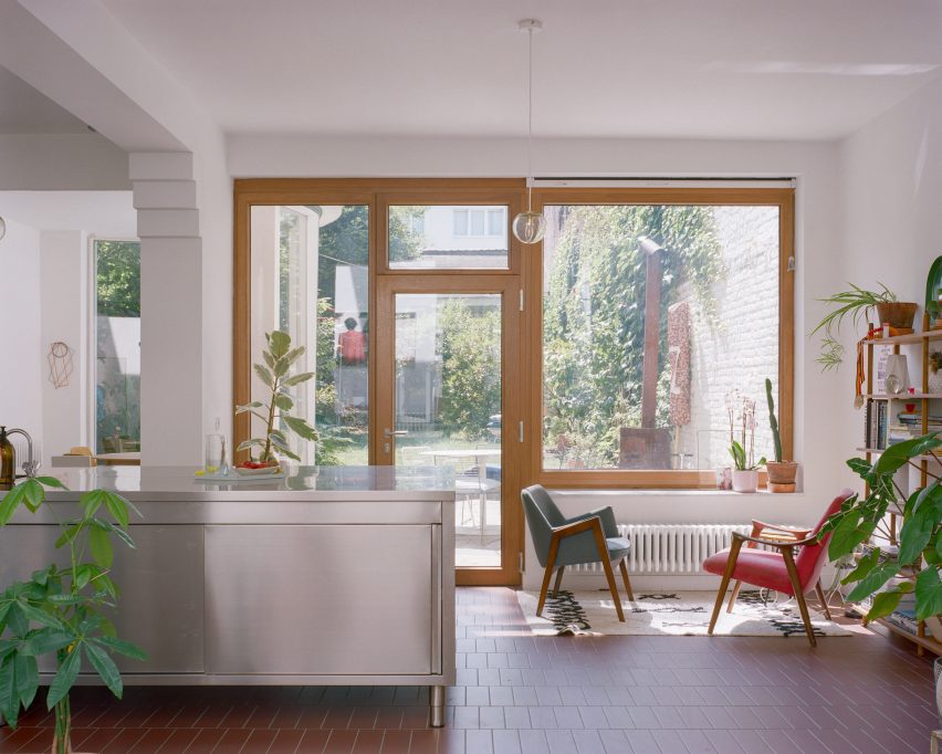 Open-plan kitchen and dining room with a steel island and glass doors leading to a garden