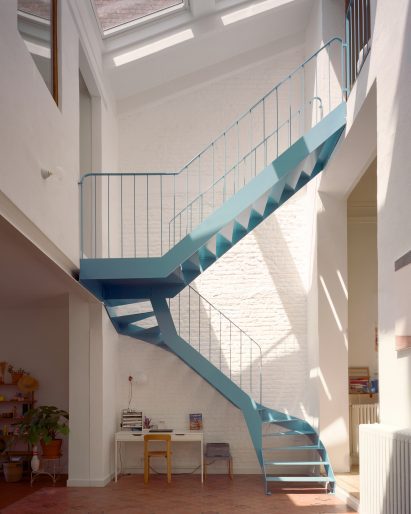 Blue metal staircase in the atrium of a Belgian home