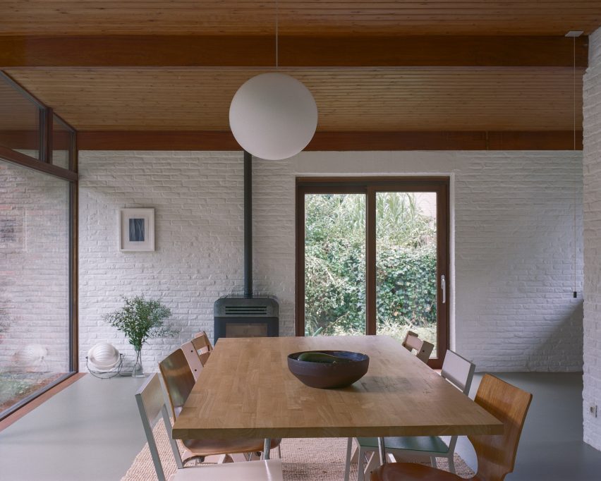 Dining room with white brick walls and timber ceilings