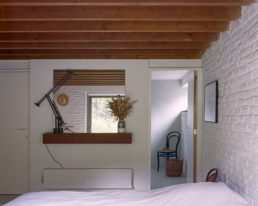 Bedroom with white brick walls and wooden beams