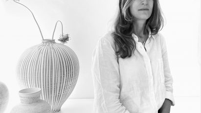 Black and white portrait of Elisa Vago with vases in the background