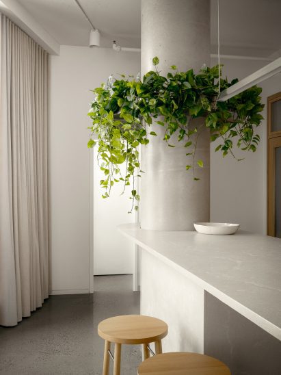 A kitchen island with rounded ends incorporates a structural concrete column