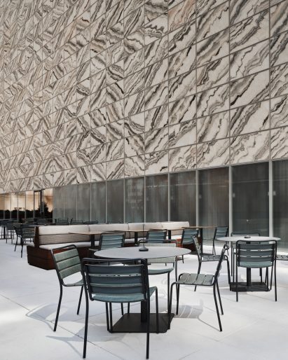 Outdoor dining terrace in front of marble building facade
