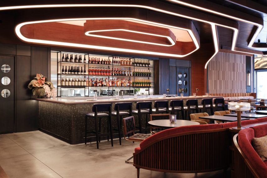 A photograph of a hotel bar in tones of beige, brown and red