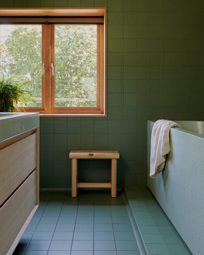 Bathroom with green tiles and terrazzo bath and basin