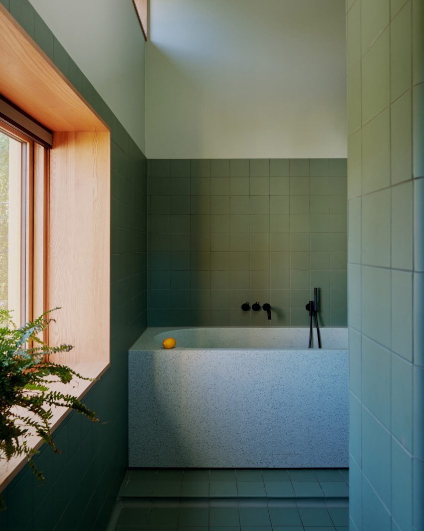 Bathroom with green tiles and terrazzo bath and basin