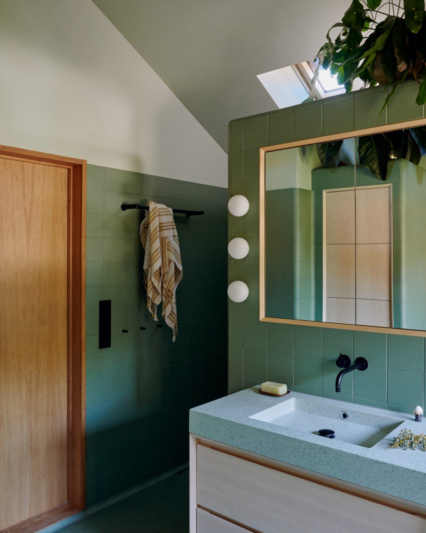 Bathroom with green tiles and terrazzo bath and basin