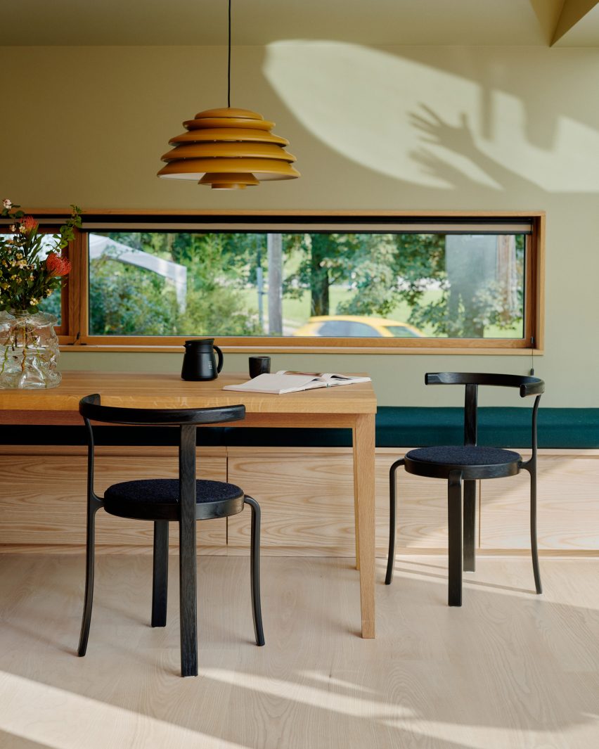 Dining table with green wall and yellow pendant