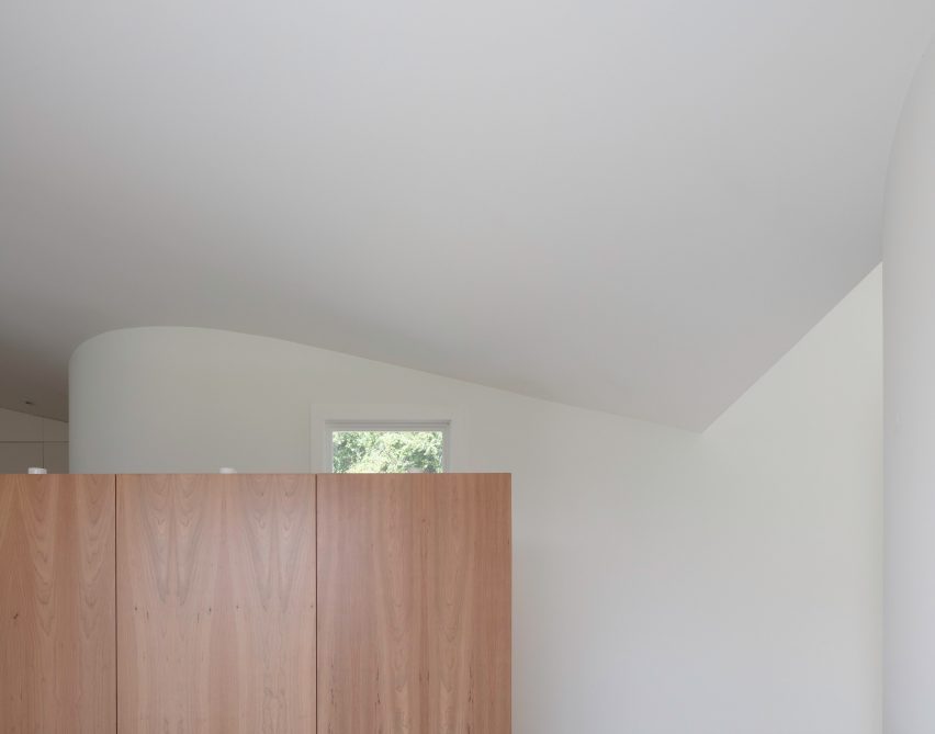A window peeking over wood cabinetry