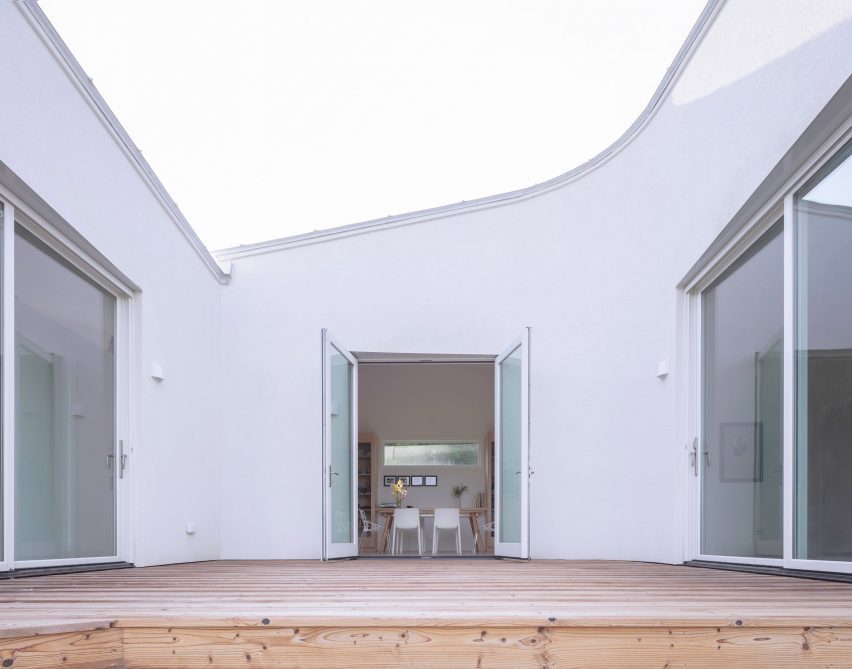 A wooden platform on the inside of a corner of a house