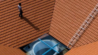 Person walking on a red-tiled roof on a home by The Bloom Architects