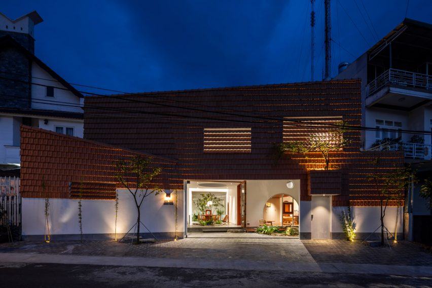 Exterior of a red-tiled home in Vietnam lit up at night