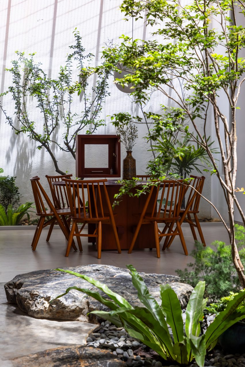 White dining room with wood furniture and planting