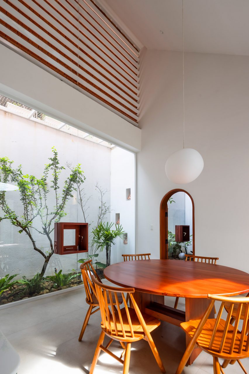 Dining room with a planted courtyard at Tile House by The Bloom Architects