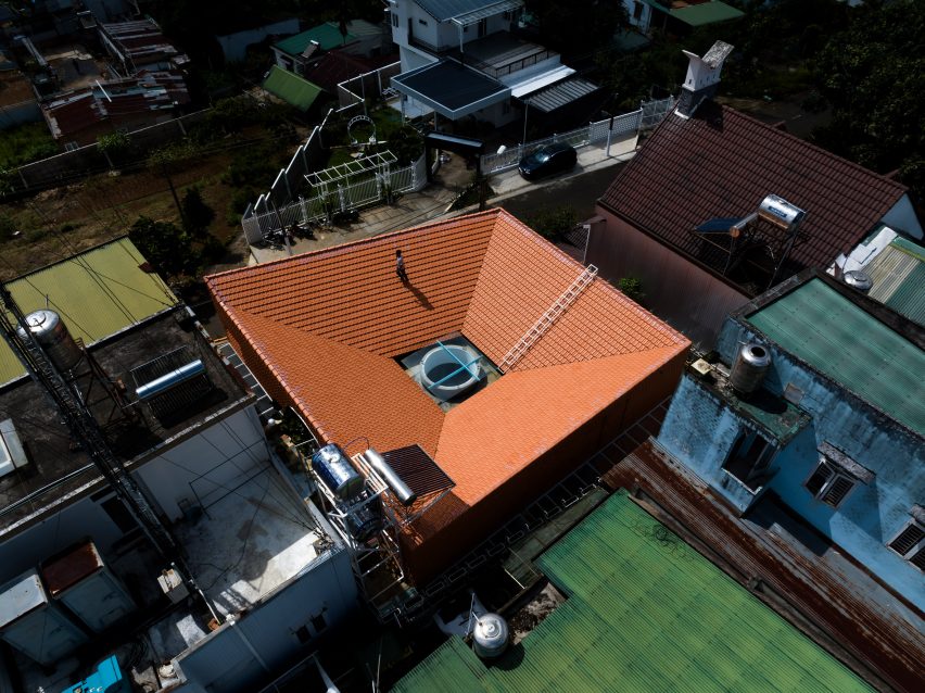 Aerial view of Tile House with a sloping red-tiled roof by The Bloom Architects