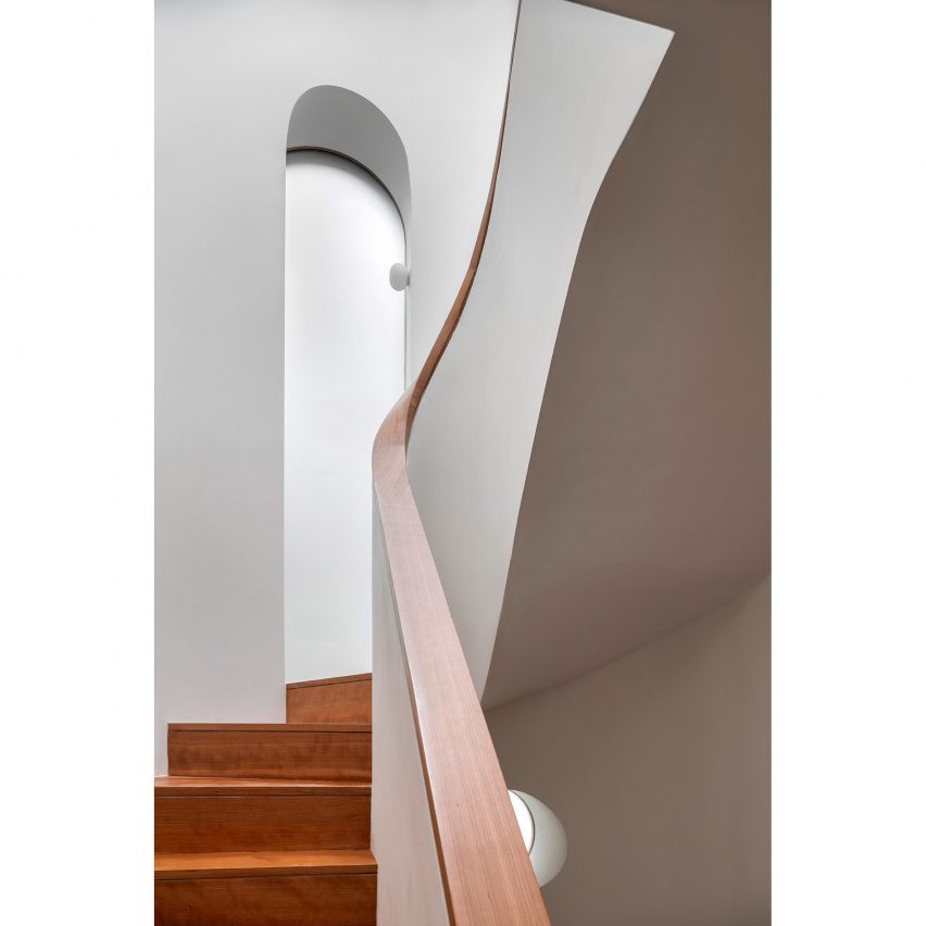Wooden bannister curving around past arched doorway Wimbledon Villa