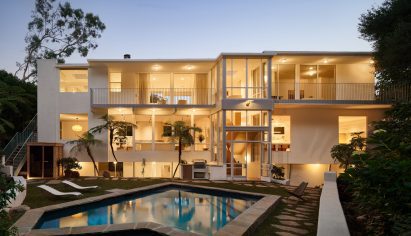 Three-storey modernist house seen at dusk