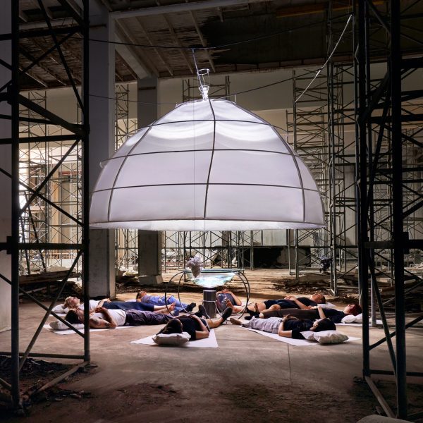 Photo of people lying under a lighting installation