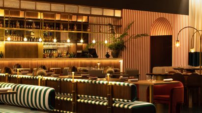 Banquette sofas and brass and glass lights at Anfibio, Lisbon by Bacana Studio