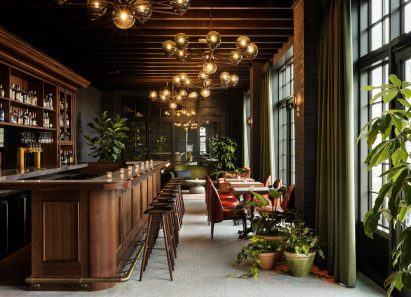 Kamper's rooftop cocktail bar with exposed brickwork and dark wood accents