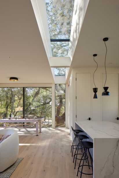 a white interior with marble island and large windows