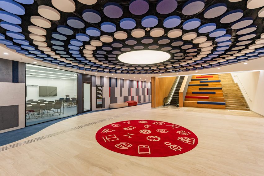Photo of an open landing with a light and acoustic feature overhead and open staircase seating to one side at the University of Wollongong (UOW) College Hong Kong campus in Tai Wai