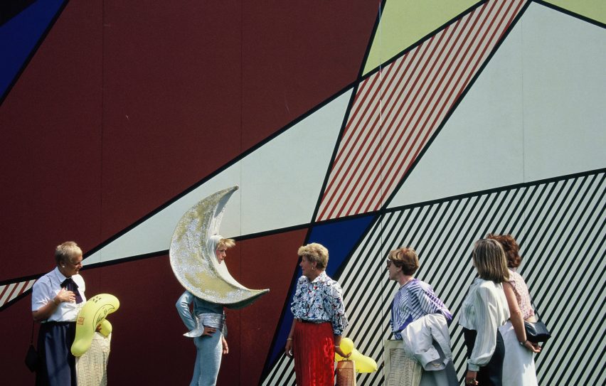 Person with moon mask on in line