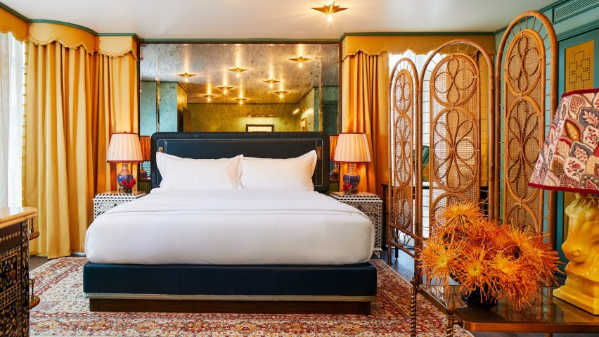 Bed in hotel room with screen and gilded mirrors and star lights